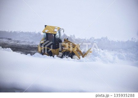 雪に覆われた駐車場を除雪する除雪車両 135935288