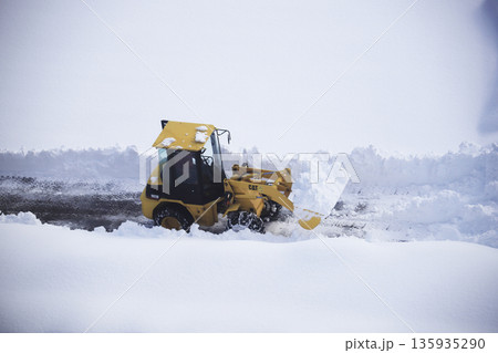 雪に覆われた駐車場を除雪する除雪車両 135935290