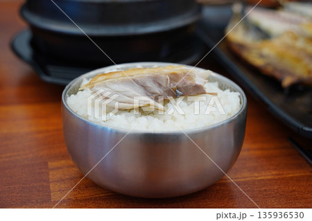 steamed white rice with a piece of grilled mackerel on top, a popular Korean home meal steamed white rice with a piece of grilled mackerel on top, a popular Korean home meal 135936530