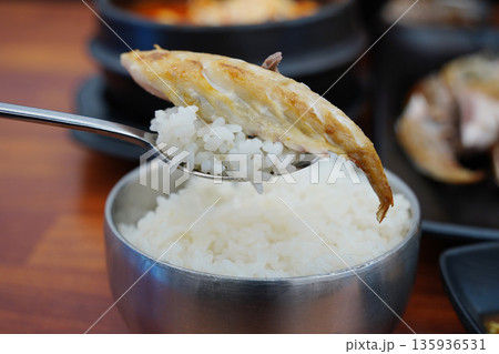 steamed white rice with a piece of grilled mackerel on top, a popular Korean home meal 135936531