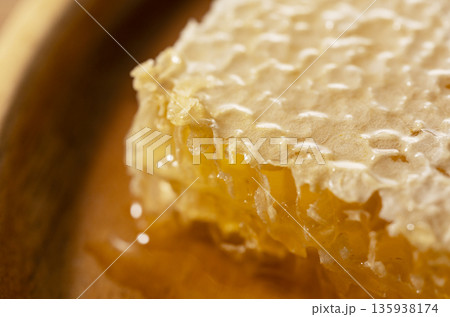 黄金色に輝くハチミツが溢れるコムハニーの超接写マクロ画像 黄金色に輝くハチミツが溢れるコムハニーの超接写マクロ画像 135938174