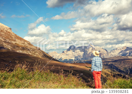 Mountain landscape on a sunny day. A woman stays and looks at the mountains. Grossglockner High Alpine Road. Austria Mountain landscape on a sunny day. A woman stays and looks at the mountains. Grossglockner High Alpine Road. Austria 135938281