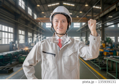 工場とガッツポーズする作業員 135939131