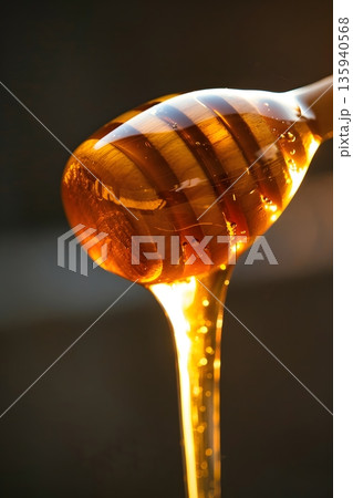 木製ディッパーから滴る黄金のはちみつ 135940568