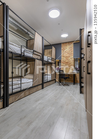 Loft hostel dormitory with industrial elements and wooden bunk beds 135942510