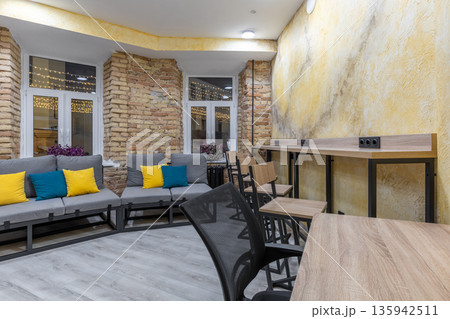 Modern hostel common area with lounge seating and coworking zone 135942511