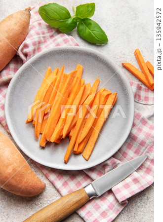 Raw sweet potato sticks on plate with basil 135942572