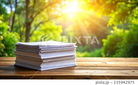 An old literature book stack and paper pile rests on a brown wooden library table with a green nature background for school education 135942975