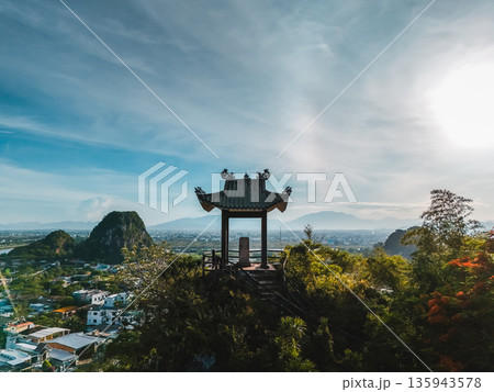 Pagoda pavilion atop Marble Mountains aerial view blue sky, Temple lookout on karst peak overlooking Danang valley panorama 135943578