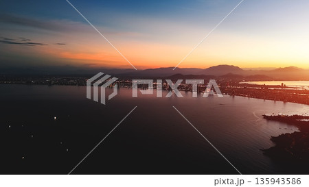 Danang aerial sunset over city sea and mountains skyline, Evening panorama Da Nang coast city lights golden hour bay Danang aerial sunset over city sea and mountains skyline, Evening panorama Da Nang coast city lights golden hour bay 135943586
