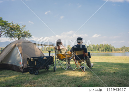 asian couple fun happy and relax with camping and picnic at side of lake with mountain background 135943627