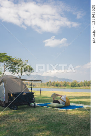 asian couple fun happy and relax with camping and picnic at side of lake with mountain background asian couple fun happy and relax with camping and picnic at side of lake with mountain background 135943629