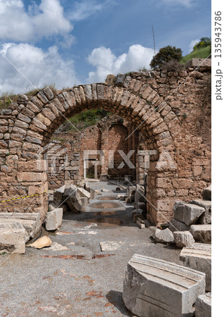 Ancient stone archway and scattered ruins at Ephesus archaeological site Selcuk Turkey Ancient stone archway and scattered ruins at Ephesus archaeological site Selcuk Turkey 135943786