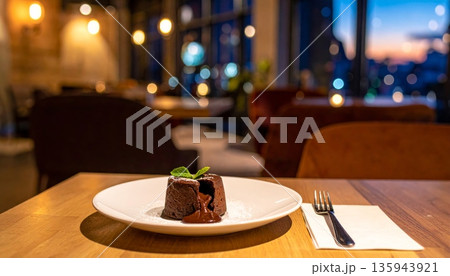 A delicious gourmet Christmas dinner table setting featuring a white plate with a succulent beef steak and a slice of chocolate nut cake for dessert served with red wine 135943921