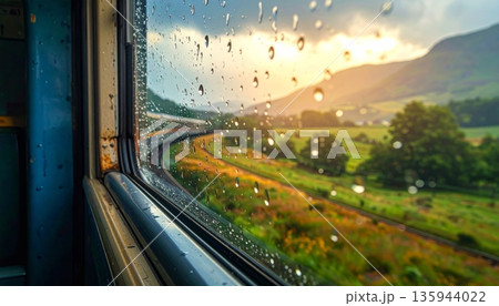 A fast train speeds along the railway at sunrise as the morning sun lights up the horizon of a vast landscape where the highway and nature meet on a long travel journey 135944022