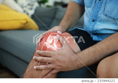 Close-up of hand holding painful injured knee with red inflamed spot and X-ray bone skeleton joint overlay. Medical concept of fracture, arthritis, tendonitis, or muscle ache in outdoor background. 135944221