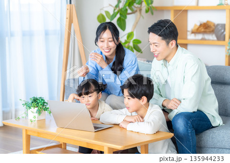 リビングでパソコンを見る4人家族 135944233