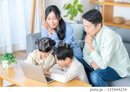 リビングでパソコンを見る4人家族 135944234