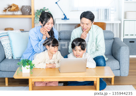 リビングでパソコンを見る4人家族 135944235