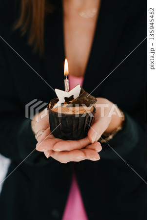 Cupcake With Candle In Female Hands Cupcake With Candle In Female Hands 135945482