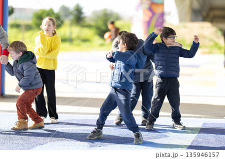 Group of diverse children actively playing outdoors together Group of diverse children actively playing outdoors together 135946157