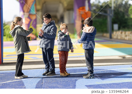 Children playing outdoor hand game expressing joy 135946264