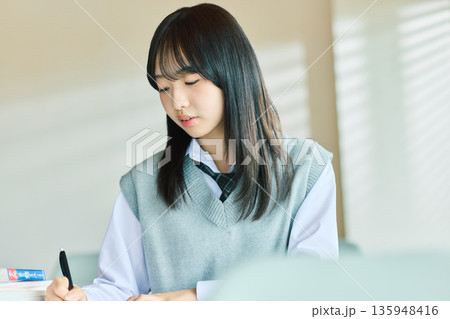 授業を受ける女子学生 135948416