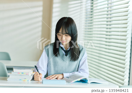 授業を受ける女子学生 135948421