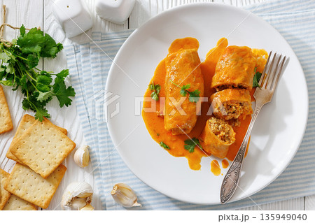 Stuffed cabbage rolls with quinoa and tomato sauce 135949040