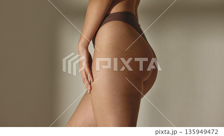 Close up of female hips in brown lingerie in studio background 135949472