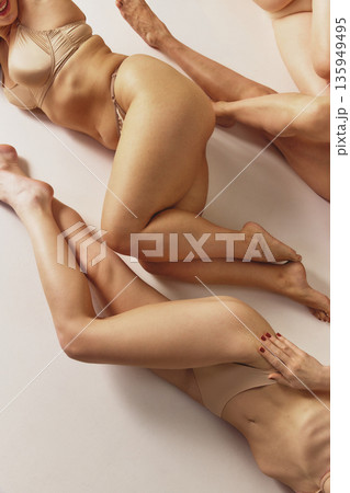 Women in beige lingerie lying together studio composition. Women in beige lingerie lying together studio composition. 135949495
