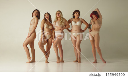Group of diverse women posing confidently in lingerie on neutral studio background. Group of diverse women posing confidently in lingerie on neutral studio background. 135949500