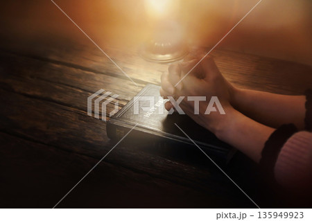 A Christian background of praying and meditating with both hands clasped over the Holy Bible, the Word of Life. A Christian background of praying and meditating with both hands clasped over the Holy Bible, the Word of Life. 135949923