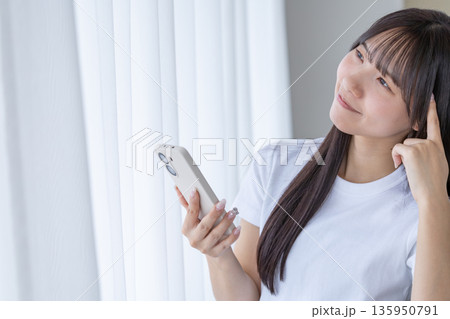 スマートフォンを持って考える若い女性 スマートフォンを持って考える若い女性 135950791