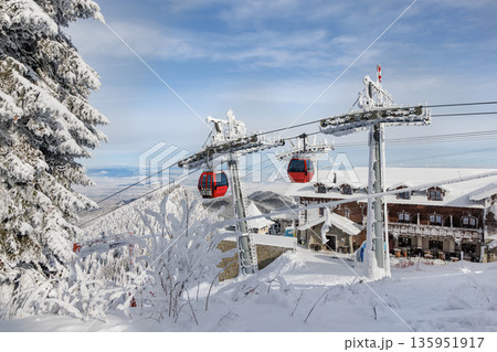 Red cable car in snowy forest landscape over ski slope from Transylvania in Poiana Brasov, Romania 135951917