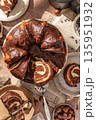 Chocolate marble bundt cake or zebra cake with chocolate glaze sliced on brown table background top view 135951932