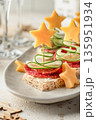 Cheese salami appetizers with cucumber on a plate. Delicious festive canapes for New Year party close up 135951934