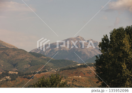 A sweeping mountain landscape in August 2025, with tiered, wooded hills under a clear summer sky. A sweeping mountain landscape in August 2025, with tiered, wooded hills under a clear summer sky. 135952096