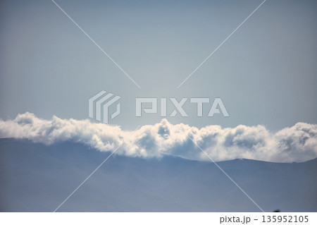 A sweeping mountain landscape in August 2025, with tiered, wooded hills under a clear summer sky. A sweeping mountain landscape in August 2025, with tiered, wooded hills under a clear summer sky. 135952105