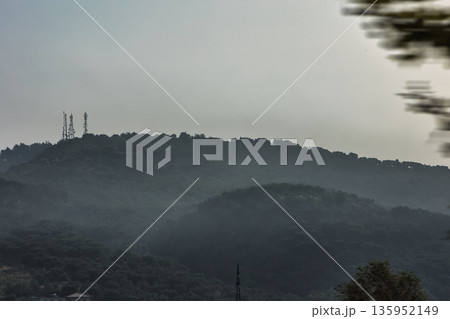 A sweeping mountain landscape in August 2025, with tiered, wooded hills under a clear summer sky. A sweeping mountain landscape in August 2025, with tiered, wooded hills under a clear summer sky. 135952149