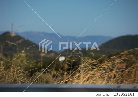 A sweeping mountain landscape in August 2025, with tiered, wooded hills under a clear summer sky. A sweeping mountain landscape in August 2025, with tiered, wooded hills under a clear summer sky. 135952161
