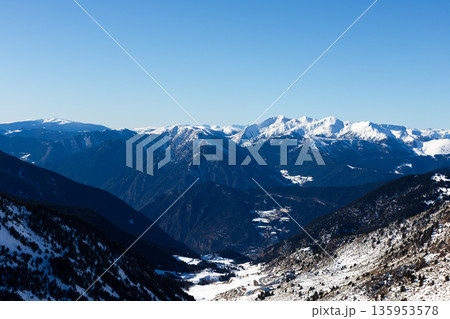 Majestic snow capped mountains under clear blue sky in winter landscape Majestic snow capped mountains under clear blue sky in winter landscape 135953578