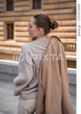 Young beautiful woman wearing coat walking in the city centre of Prague, Europe Young beautiful woman wearing coat walking in the city centre of Prague, Europe 135953889