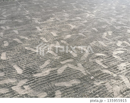 Plowed field with footprints, background photo texture Plowed field with footprints, background photo texture 135955915