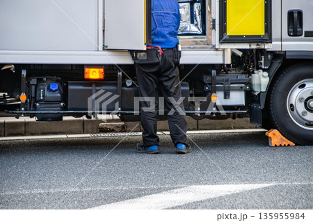 配送トラックと荷物を取り出す人 配送トラックと荷物を取り出す人 135955984