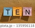Word ten on leaflets glued to the wall 135956118