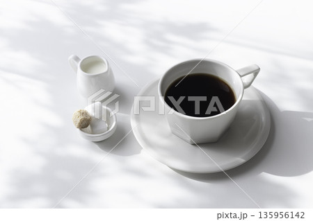 白背景のコーヒーとミルク、角砂糖 木漏れ日の影と余白 白背景のコーヒーとミルク、角砂糖 木漏れ日の影と余白 135956142