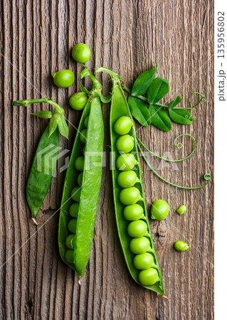 Green peas arranged on wooden surface with pods Green peas arranged on wooden surface with pods 135956802