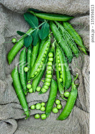 Green peas scattered on fabric surface 135956813