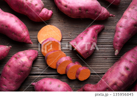 Sweet potato slices surrounded by whole tubers 135956845
